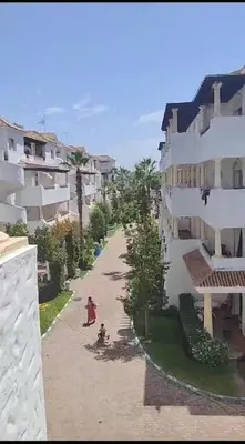 a person standing on a sidewalk next to a building at Garden Beach in Sidi Rahal