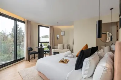 a bedroom with a large white bed and a living room at Oasis Residence by GoodMove - Casablanca in Casablanca