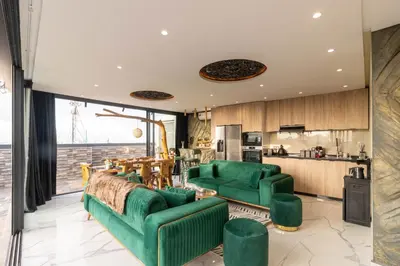 a living room with green furniture and a kitchen at Casablanca Luxury Penthouse with Jacuzzi & Views in Casablanca
