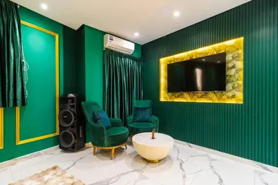 a living room with green walls and a tv and chairs at Casablanca Luxury Penthouse with Jacuzzi & Views in Casablanca