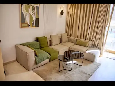 a living room with a couch and a table at Cosy studio disponible sur maarif princesses in Casablanca