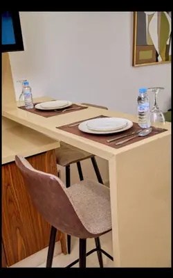 a table with a chair and plates on it at Cosy studio disponible sur maarif princesses in Casablanca