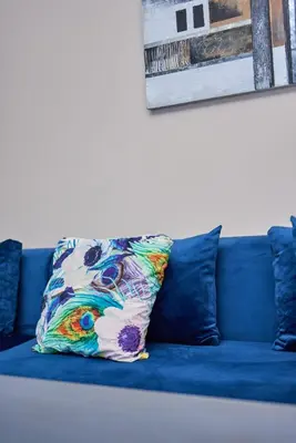 a blue couch with a colorful pillow on it at Joli studio disponible sur maarif boulevard danfa in Casablanca