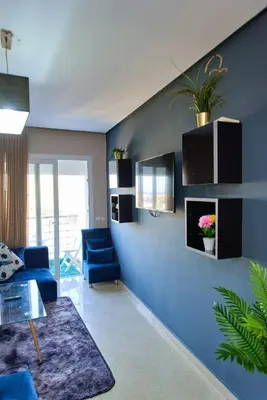 a living room with blue walls and blue chairs at Joli studio disponible sur maarif boulevard danfa in Casablanca
