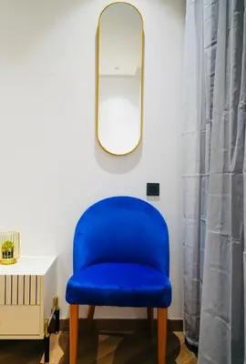 a blue chair in a room with a mirror at Les princesses studio confortable in Maarif