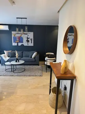 a living room with a blue couch and a mirror at Centrale studio with Nice terasse in Maarif