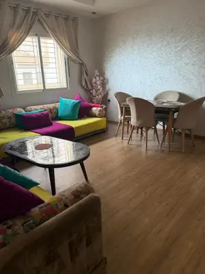 a living room with a couch and a table and chairs at Cozy Sunny Apartment Near Beach nd Local Amenities in Dar Ben Abdallah Ben Dehbi