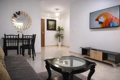 a living room with a couch and a tv on a wall at appart a 5min de l'hôpital Mohamed 6 in Casablanca