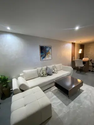 a living room with a white couch and a coffee table at Residence Carlton House2 STUDIOS in Roches Noires