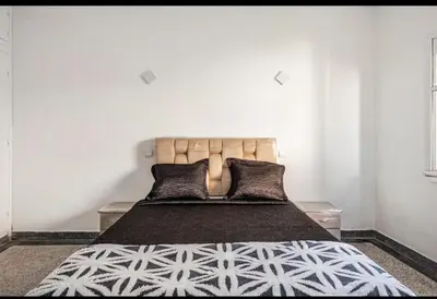 a bedroom with a large bed with black and white sheets at Villa à harhora in Temara