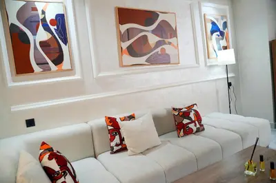 a white couch in a living room with paintings at Evasion chic et central au coeur de Maarif in Casablanca