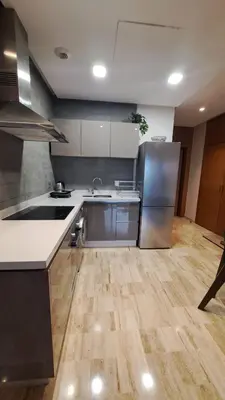 a kitchen with a stainless steel refrigerator and wooden floors at Luxury Appart Finance City in Casablanca