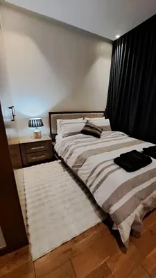 a bedroom with a large bed and a night stand at Luxury Appart Finance City in Casablanca