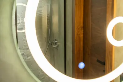 a mirror with a wooden door in a bathroom at Luxury one bedroom in Triangle d'or with rooftop pool in Casablanca