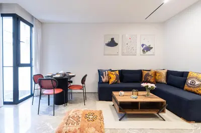 a living room with a blue couch and a table at Luxury one bedroom in Triangle d'or with rooftop pool in Casablanca