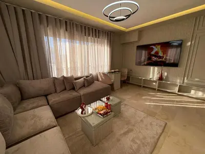 a living room with a couch and a tv at Premium Studio Oasis Secure Parking High Speed Fiber Wifi Luxoria Oasis Residence Near CFC & 70p Smart TV in Casablanca