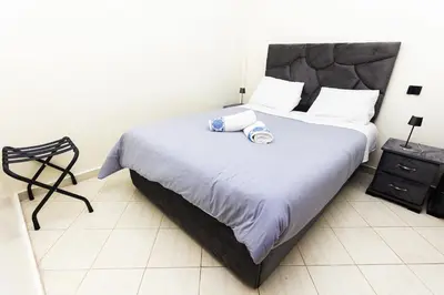 a bedroom with a large bed and a chair at Apartement complets pres Ocean port de Casablanca in Casablanca