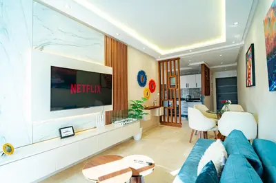 a living room with a blue couch and a tv at Studio Balcony Netflix, Near CFC, Parking in Casablanca