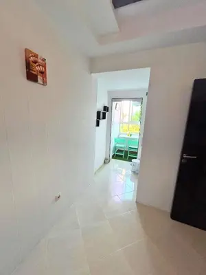 a room with white walls and a hallway with a door at Charming apartment near Mohammedia station in Mohammedia