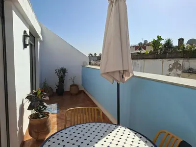 a patio with a table and an umbrella on a balcony at Private and sunny apartment in central Casa in Casablanca