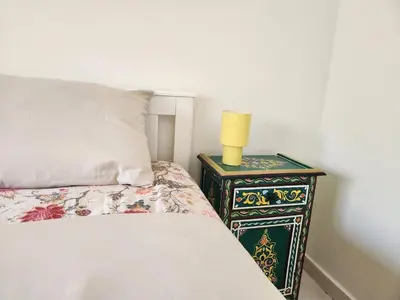 a bedroom with a bed and a lamp on a night stand at Private and sunny apartment in central Casa in Casablanca