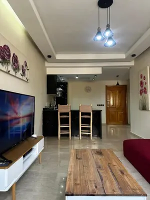 a living room with a flat screen tv and a table at Appartement centre casablanca in Casablanca