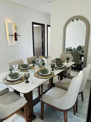 a dining room with a table and chairs and a mirror at Appartement la siesta beach resort in Mohammedia