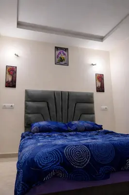 a bed with a blue comforter in a bedroom at Appart luxe in Rabat