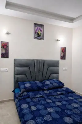 a bedroom with a blue bed with a black headboard at Diamonds in Rabat