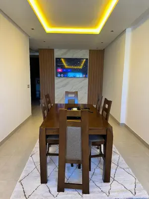 a dining room with a wooden table and chairs at luxury apartment in the city center in Rabat