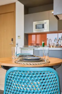 a wooden table with a blue chair in a kitchen at Bright Studio at Bliving with Sunny Terrace 1 BR in Casablanca
