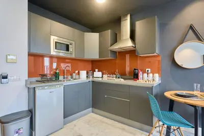 a kitchen with blue cabinets and a table with chairs at Bright Studio at Bliving with Sunny Terrace 1 BR in Casablanca