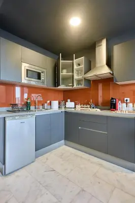 a large kitchen with blue cabinets and a microwave at Bright Studio at Bliving with Sunny Terrace 1 BR in Casablanca