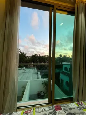 a bedroom with a large window looking out on a roof at Anfaflore2 in Casablanca