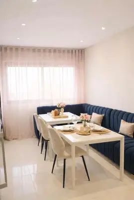 a living room with a table and a blue couch at Corniche in Casablanca