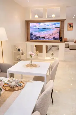 a living room with a white table and a tv at Corniche in Casablanca