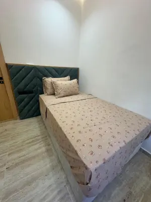 a small bed in a room with a mattressvisor at Apartment Témara Ideal Center High Standing in Temara