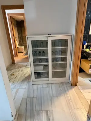 a glass cabinet in a kitchen with a wooden floor at CMN airport apartment in Nouaseur