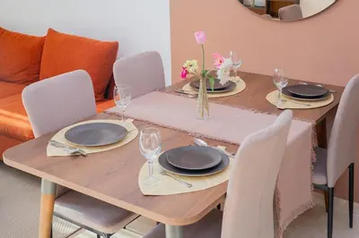 a dining room table with chairs and a wooden table with plates at Neon Terrace in 12th Floor CFC Casablanca in Casablanca