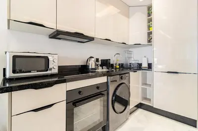 a kitchen with a microwave and a washer and dryer at Appartement de luxe sur la Corniche in Casablanca