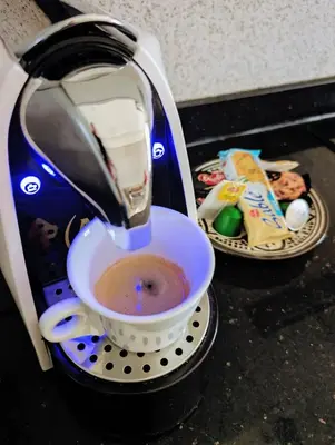 a coffee maker is pouring coffee into a cup at Pool view apartment, beach access, nature & quiet in Mansouria