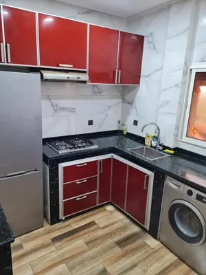 a kitchen with red cabinets and a washing machine at Adnani in Temara