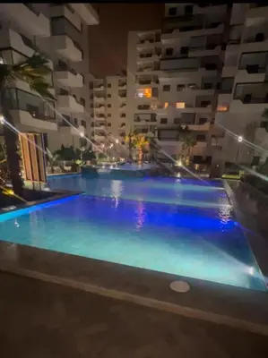 a large swimming pool in a building at night at Beautiful appartement with pool and ocean view in Aïn Harrouda