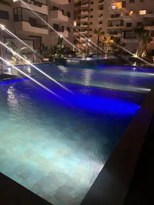 a swimming pool at night with blue lights at Beautiful appartement with pool and ocean view in Aïn Harrouda