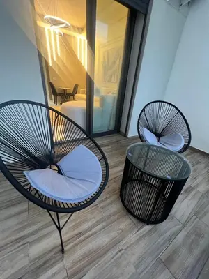two chairs and a table in a room at Beautiful appartement with pool and ocean view in Aïn Harrouda