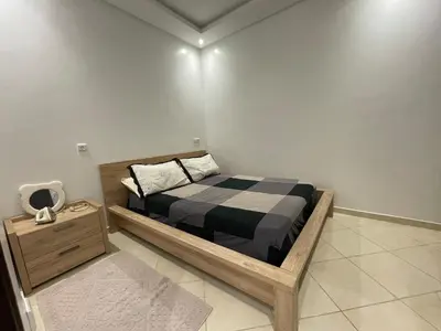 a small bedroom with a bed and a night stand at Apparemment Moderne à Temara in Temara