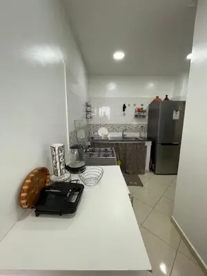 a kitchen with a white counter top and a refrigerator at Apparemment Moderne à Temara in Temara