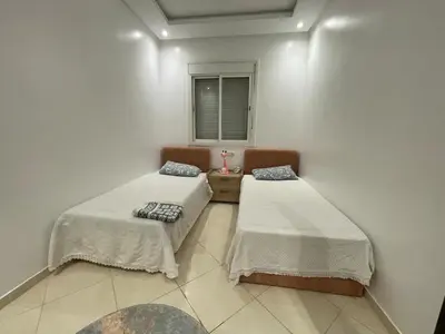 a room with two beds and a window at Apparemment Moderne à Temara in Temara