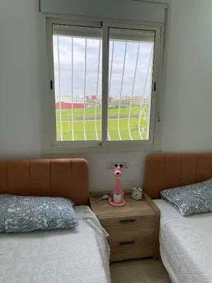 a bedroom with two beds and a window at Apparemment Moderne à Temara in Temara
