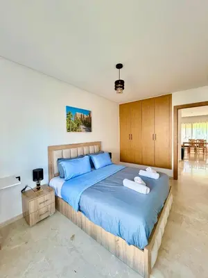 a bedroom with a large bed with blue sheets at Bungalow à 1 minute de la plage in Rabat